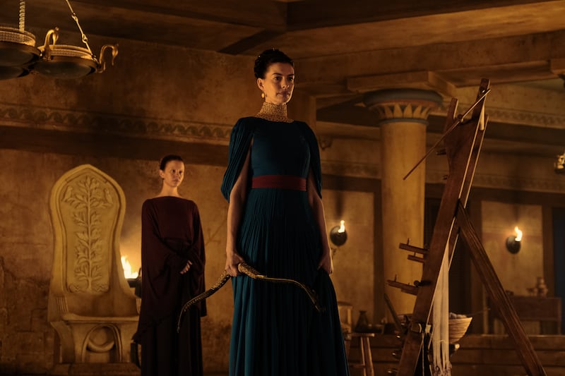 L to R: Mia Goth is Melantho and Anne Hathaway is Penelope in THE ODYSSEY, written, produced, and directed by Christopher Nolan.