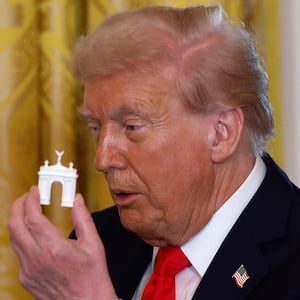 WASHINGTON, DC - OCTOBER 15: U.S. President Donald Trump holds models of an arch as he delivers remarks during a ballroom fundraising dinner in the East Room of the White House on October 15, 2025 in Washington, DC. Trump hosted organizations and individuals for a fundraising dinner for the new $250 million ballroom addition currently under construction at the White House. (Photo by Kevin Dietsch/Getty Images)