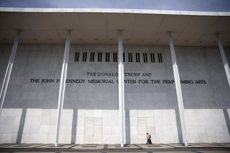 A person walks under the sign for The John F. Kennedy Memorial Center for the Performing Arts on June 5, 2026 in Washington, DC after lawyers the day before sent a memo directing staff to remove Donald Trump's name from the building and material by June 12.