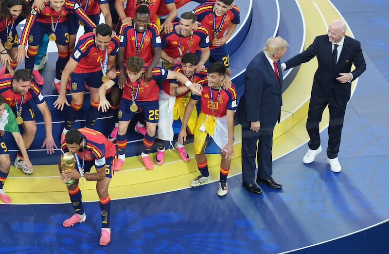 Spain's Rodri lifts the World Cup trophy alongside teammates as they celebrate winning the World Cup next to U.S. President Donald Trump and FIFA President Gianni Infantino