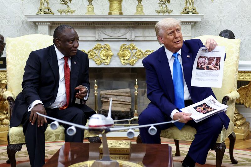 U.S. President Donald Trump shows alleged news reports as he meets South African President Cyril Ramaphosa in the Oval Office of the White House in Washington, D.C., U.S., May 21, 2025.
