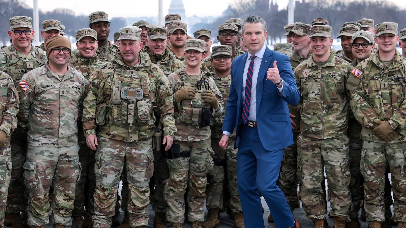 U.S. Defense Secretary Pete Hegseth poses with U.S. Army National Guard soldiers.