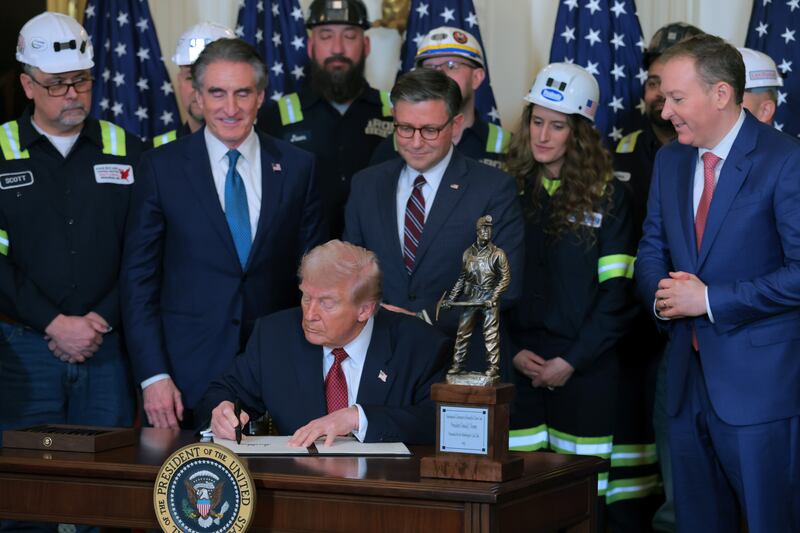 Trump signs an executive order beside Secretary of the Interior Doug Burgum, Speaker of the House Mike Johnson, and EPA Administrator Lee Zeldin during Wednesday's coal event.