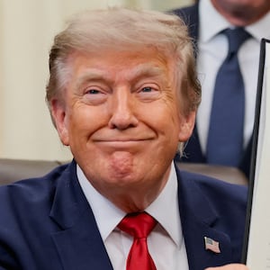 U.S. President Donald Trump holds up an executive order related to Utah protected lands after signing it in the Oval Office at the White House in Washington, D.C., U.S., July 13, 2026.
