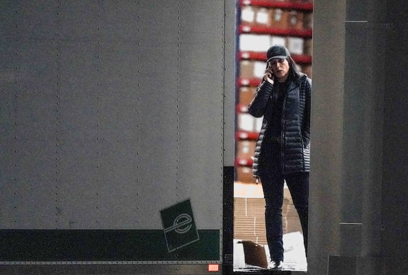 United States Director of National Intelligence Tulsi Gabbard speaks on the phone while standing at the edge of a truck loading bay after the Federal Bureau of Investigation (FBI) executed a search warrant for the Fulton County Election Hub and Operation Center in relation to the 2020 election, according to a law enforcement official familiar with the matter, in Union City, Georgia, U.S. January 28, 2026.  REUTERS/Elijah Nouvelage.