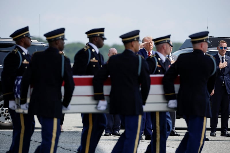 U.S. President Donald Trump salutes as members of the military carry the transfer case during a dignified transfer of the remains of U.S. Army service members Army 1st Lt Tyler James Feehan, Sgt. Angel S. Rampersad, Pvt. Isabella Gonzales.