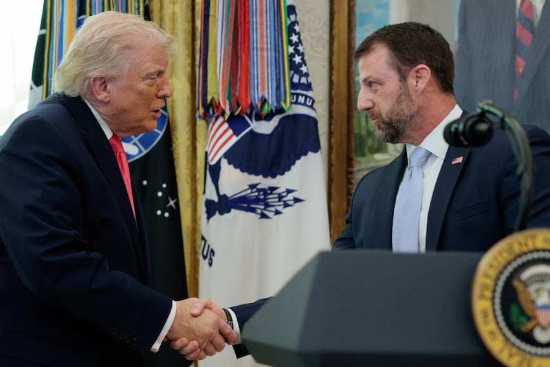 U.S. President Donald Trump shakes hands with Markwayne Mullin after he was sworn in as Department of Homeland Security (DHS) Secretary, at the White House in Washington, D.C., U.S., March 24, 2026
