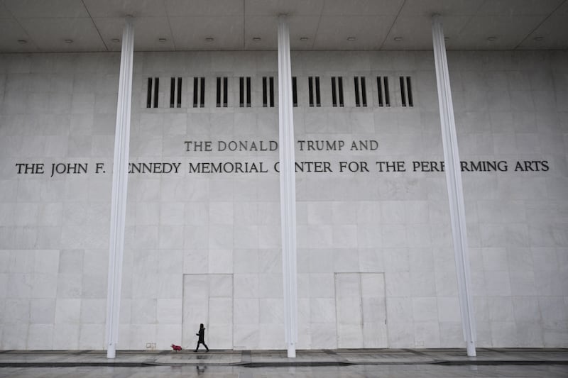 A person and a dog walk in front of the Donald J. Trump and John F. Kennedy Memorial Center for the Performing Arts in Washington, DC on January 10, 2026.