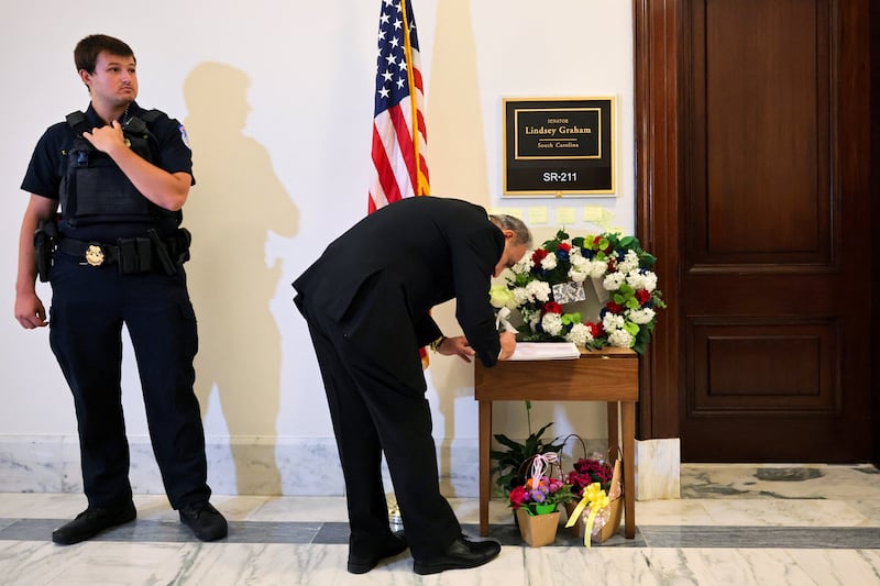 A man writes in the condolences book for late U.S. Senator Lindsey Graham (R-SC) outside his office on Capitol Hill in Washington, D.C., U.S., July 13, 2026. REUTERS/Jonathan Ernst