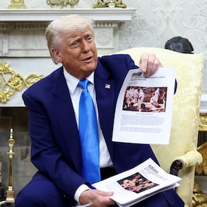 U.S. President Donald Trump shows alleged news reports as he meets South African President Cyril Ramaphosa in the Oval Office of the White House in Washington, D.C., U.S., May 21, 2025.