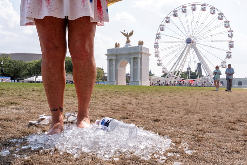 A woman stands in a pile of ice to cool off at The Great American State Fair.