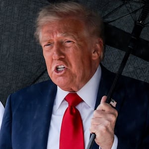 U.S. President Donald Trump holds an umbrella before boarding Air Force One, as he departs for Israel, at Joint Base Andrews, Maryland, U.S., October 12, 2025. REUTERS/Evelyn Hockstein