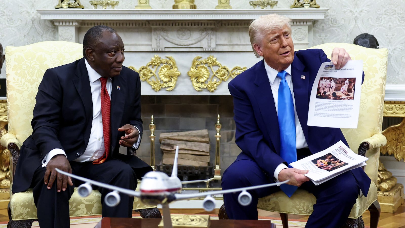 U.S. President Donald Trump shows alleged news reports as he meets South African President Cyril Ramaphosa in the Oval Office of the White House in Washington, D.C., U.S., May 21, 2025.