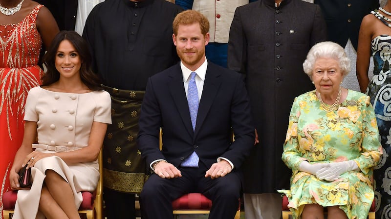 Britain’s Queen Elizabeth, Prince Harry, and Meghan, the Duchess of Sussex, pose for a picture with some of the Queen's Young Leaders at Buckingham Palace in 2018.